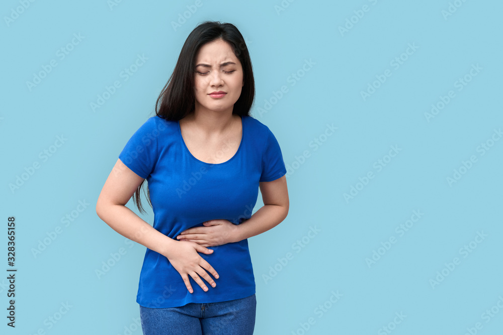 © Viktoriia - Young adult asian girl standing with spasm in stomach © Viktoriia - Young adult asian girl standing with spasm in stomach