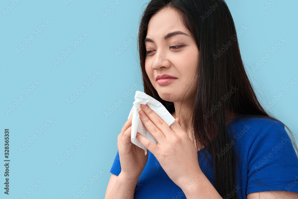Young adult asian girl with tissue and runny nose Young adult asian girl with tissue and runny nose