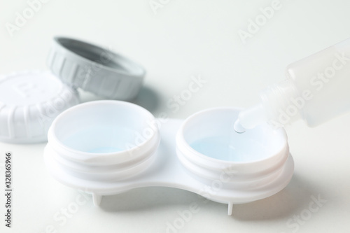 Contact lenses and liquid on white background, close up