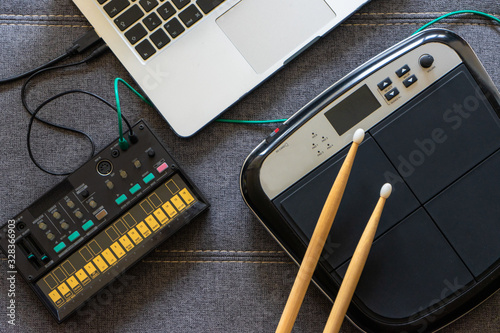 Canvas Print Top view of electronic battery with drumsticks, an fm synthesizer and a laptop
