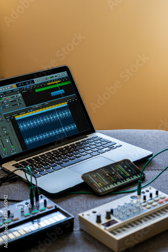 Konstfotografi Close up view of fm synthesizer, sampler, smartphone with modular synthesizer and laptop with open audio editor Electronic music concept
