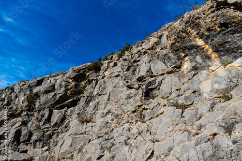 The close-up view of a cliff in the low French Alps against the background of the clear blue sky © k.dei