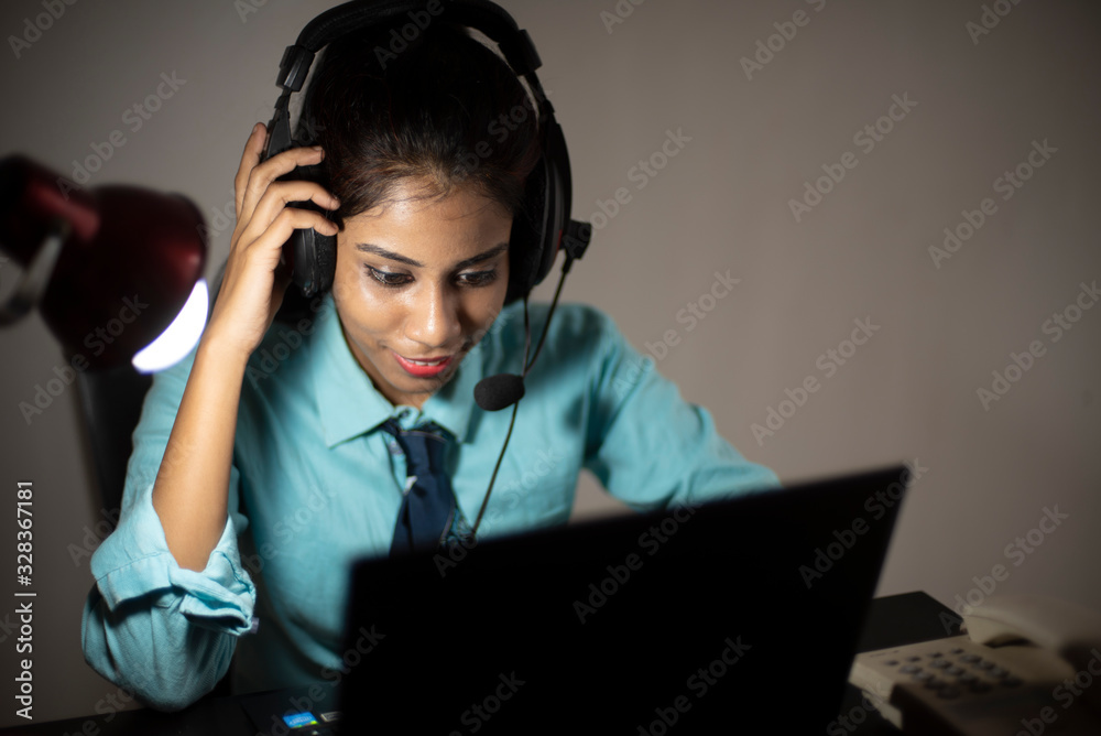 Young lady talking over phone in office. Young lady talking over phone in office.