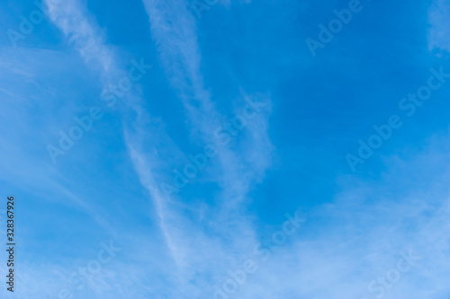 The wide angle shot of the bright blue sky with feather clouds
