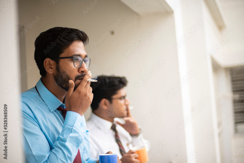 Fototapeta premium Corporate meetings with coffee/tea between young and energetic Indian Bengali bosses/officers/managers and secretary at balcony of the office building regarding a project. Indian corporate lifestyle