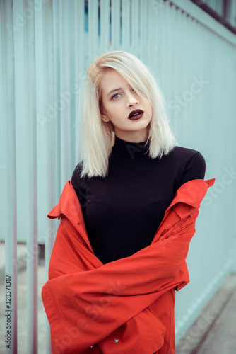 Young blonde woman in red jacket outdoors