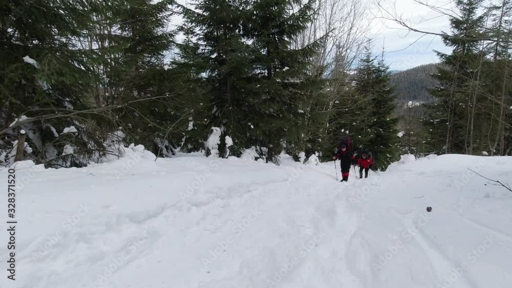 Tourists with backpacks climb the mountain on a winter day. Tourists with backpacks climb the mountain on a winter day.