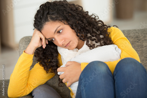 depressed young woman on sofa at home