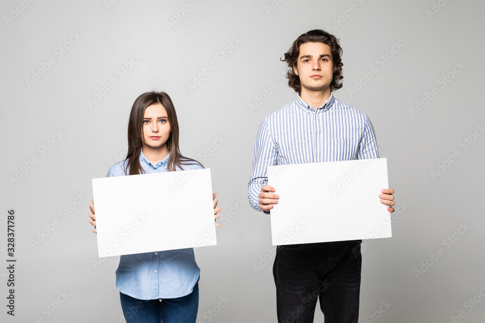 Young couple holding a blank isolated over a white background Young couple holding a blank isolated over a white background