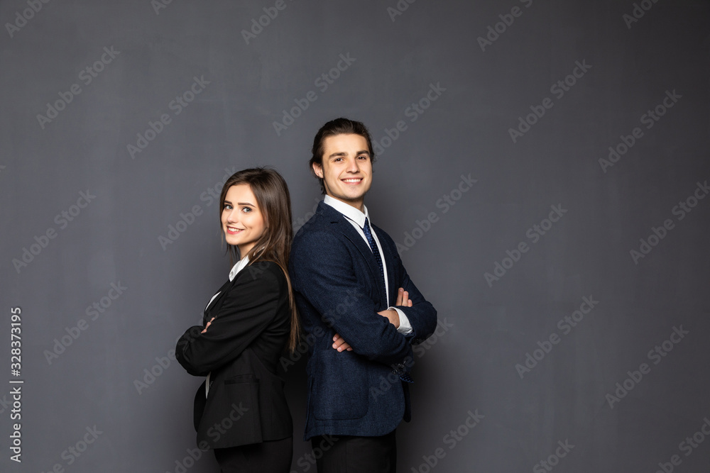Business man and woman standing back to back isolated on gray background. Teamwork concept Business man and woman standing back to back isolated on gray background. Teamwork concept