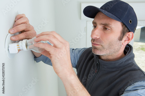 man fitting lightbulb to wall