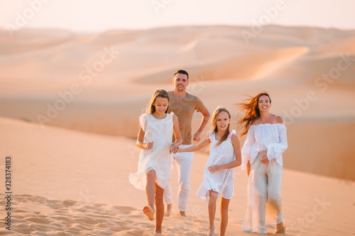 Family among dunes in Rub al-Khali desert in United Arab Emirates