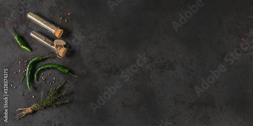 Assorted spices and herbs on dark black background