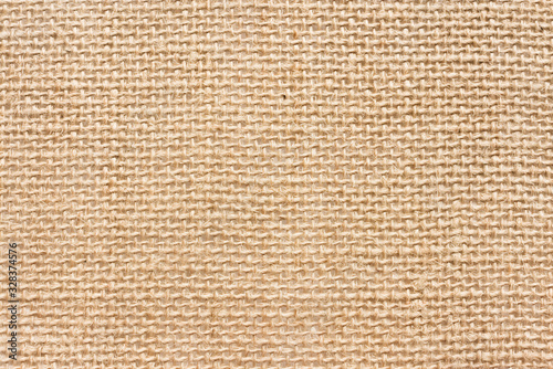 The texture of the rough linen fabric. Light rustic background. Natural material
