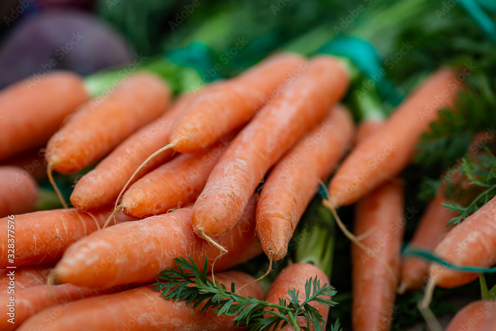 Bunches of carrots for sale on a market stall, with a shallow depth of field Bunches of carrots for sale on a market stall, with a shallow depth of field