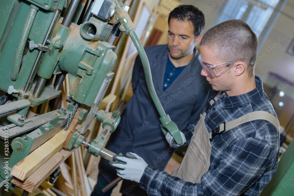 young man training to use workworking machine