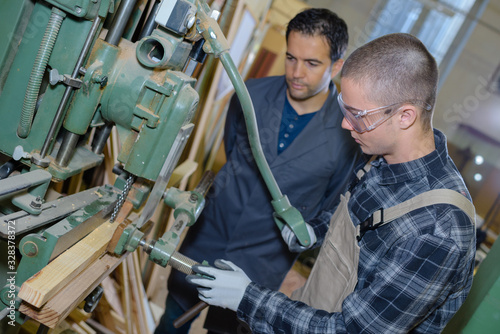 young man training to use workworking machine