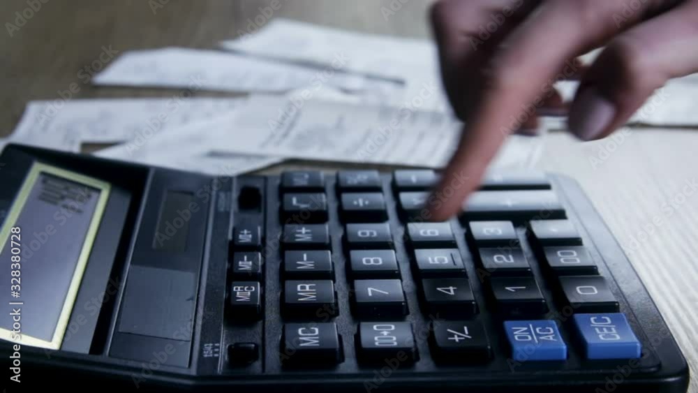 A woman with checks counts on the calculator a family budget. Family budget.  Savings, finances and economy concept