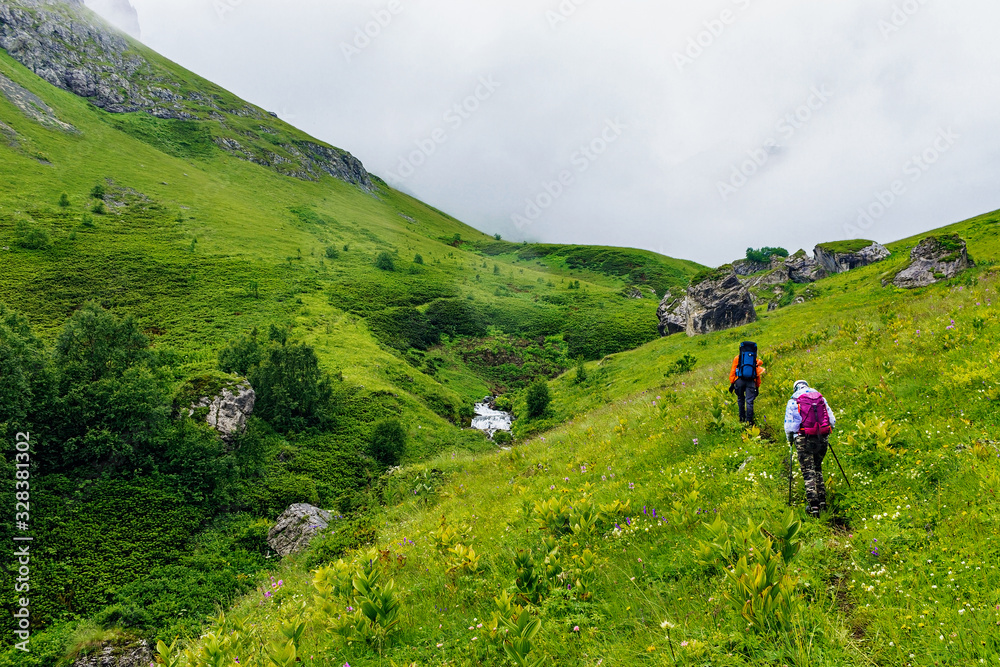 tourists with backpacks travel in the caucasus mountains