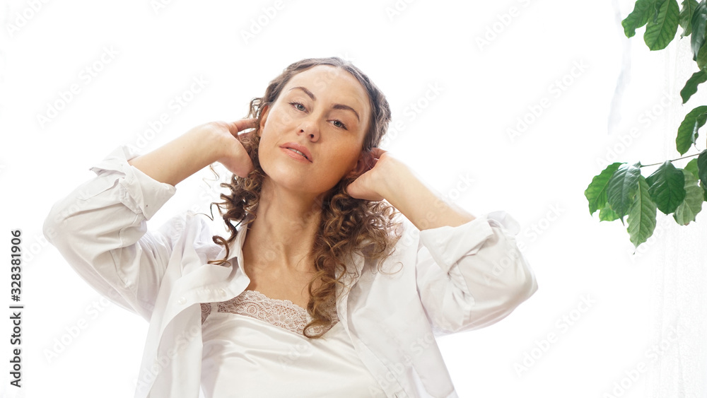Portrait of a beautiful woman sitting at home with plants and smiling at camera. Happy morning - sunny day Portrait of a beautiful woman sitting at home with plants and smiling at camera. Happy morning - sunny day