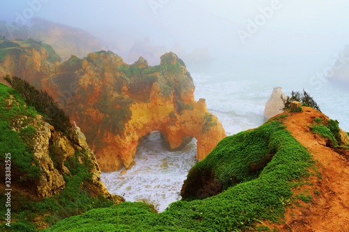 veduta delle caratteristiche formazioni rocciose vicino alla spiaggia dos Três Irmãos in una giornata di fitta nebbia ad Alvor sulla costa dell'Algarve in Portogallo