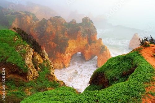 veduta delle caratteristiche formazioni rocciose vicino alla spiaggia dos Três Irmãos in una giornata di fitta nebbia ad Alvor sulla costa dell'Algarve in Portogallo photo