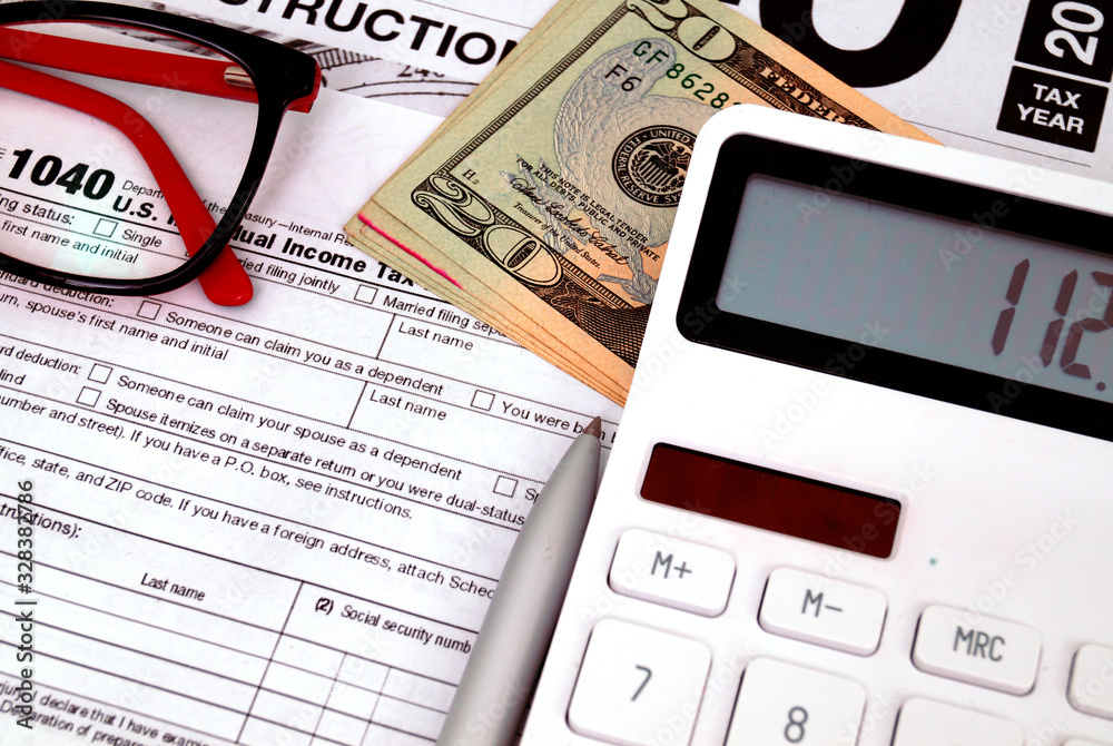 Income tax form with with calculator and money