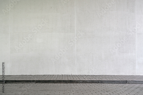 building with high white wall near empty sidewalk covered with grey stone tiles Fototapet