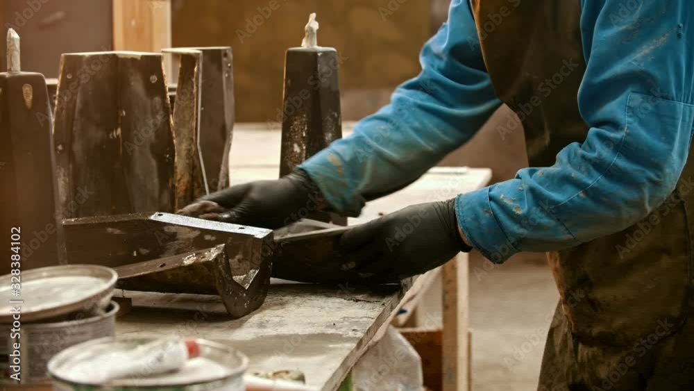 Concrete industry - worker cleaning the form for concrete casting out from the leftovers in the insides using a wet rag Concrete industry - worker cleaning the form for concrete casting out from the leftovers in the insides using a wet rag