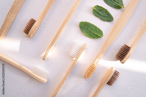 Zero waste bamboo toothbrush on white background with mint leaf
