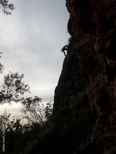 silhouette of a climber on an overhanging rock
