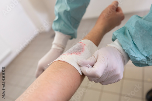 A doctor puts on a pressure bandage in a hospital