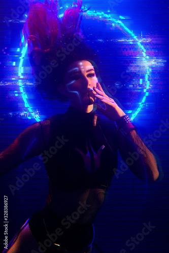 Cyberpunk style portrait of beautiful young girl poses underwater against glowing circle. Picture has noir tones