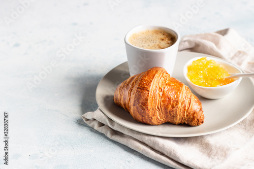 French breakfast with fresh pastries. Croissants with coffee and jam. Light grey stone background. 