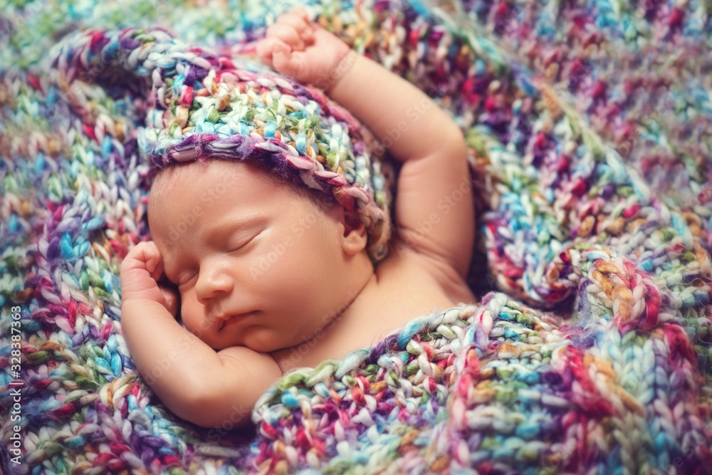 Newborn baby sleeps in a knitted scarf Newborn baby sleeps in a knitted scarf