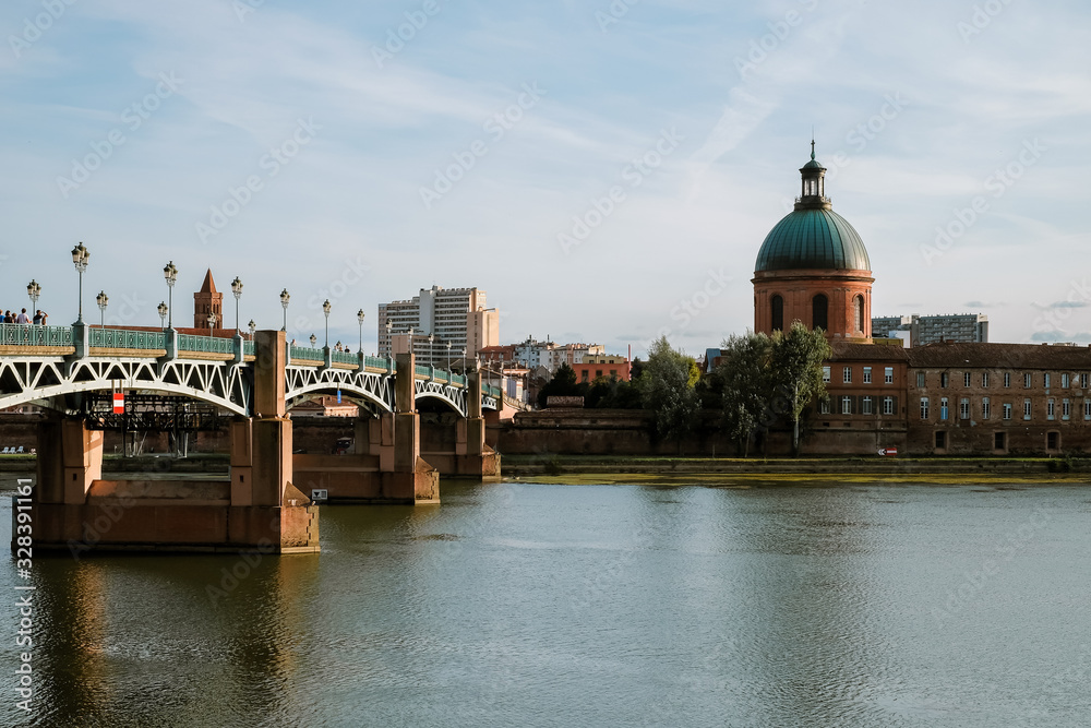 Saint-Pierre Bridge reflecting in Garonne river and Dome de la Grave in Toulouse, France