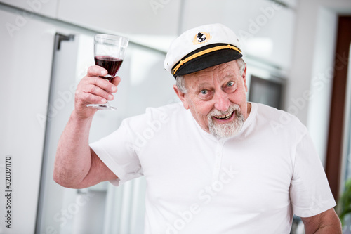 Senior man with a glass of red wine at home 