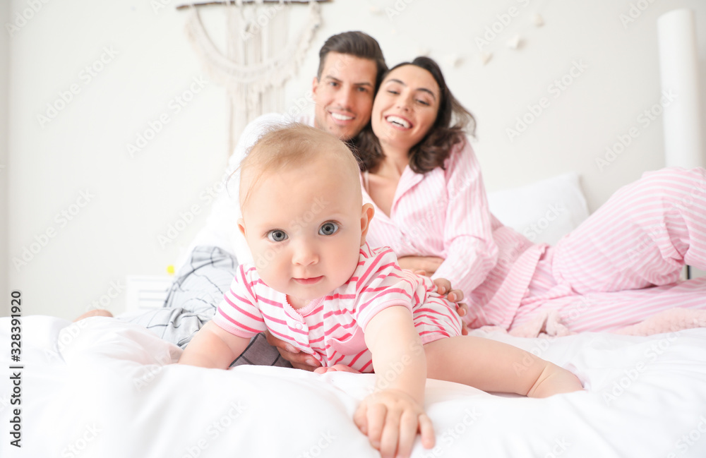 Cute baby with parents in bedroom