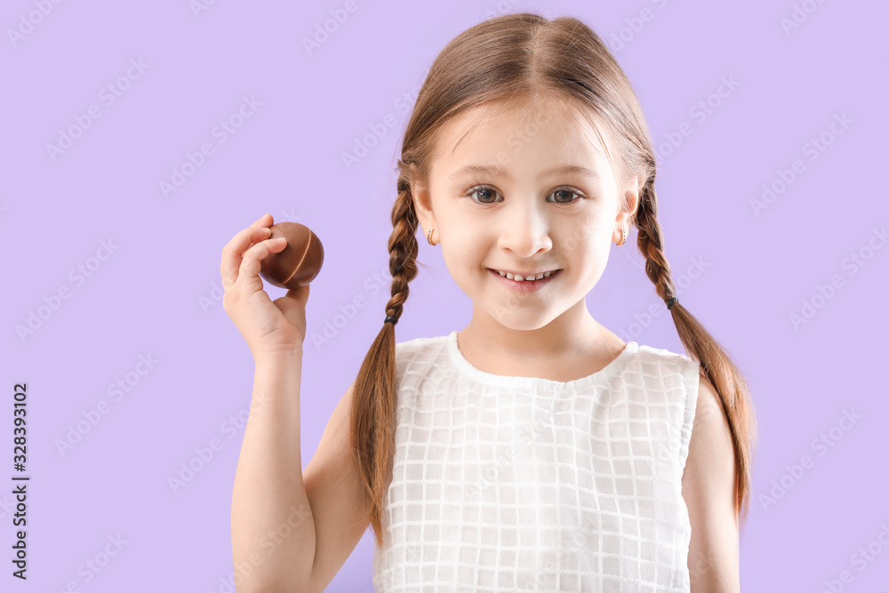 Cute little girl with sweet chocolate egg on color background Cute little girl with sweet chocolate egg on color background