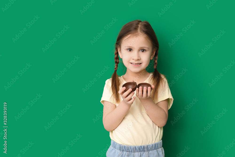 Cute little girl with sweet chocolate egg on color background Cute little girl with sweet chocolate egg on color background