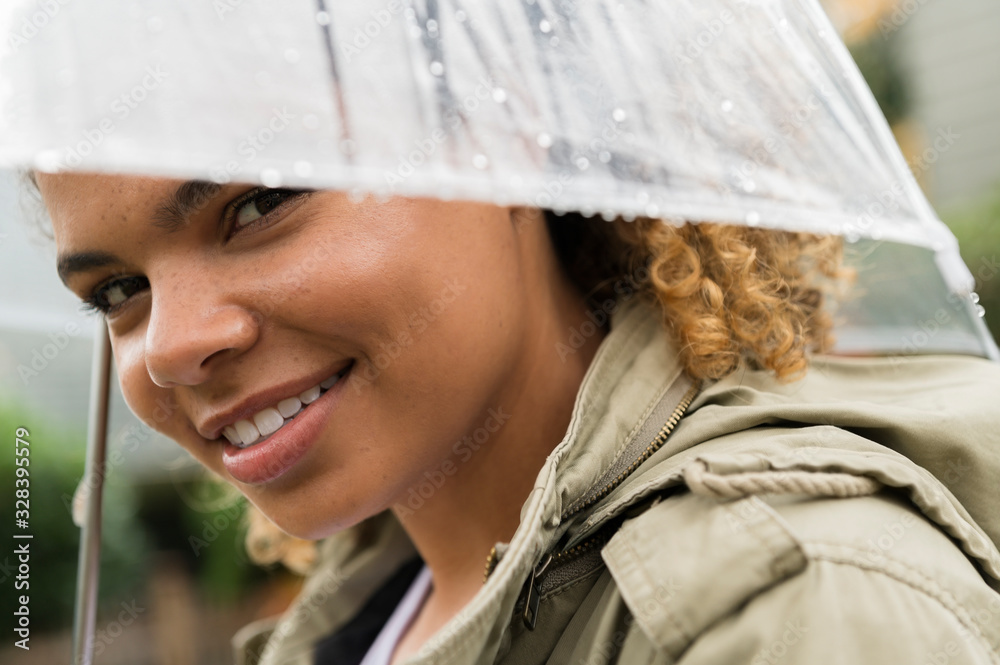 Smiling woman under wet umbrella Smiling woman under wet umbrella