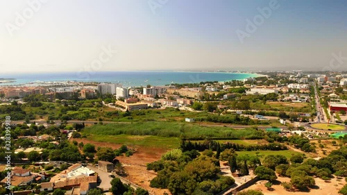 Aerial cityscape. Flyover above of Alcudia township. Popular tourist destination on Majorca (Mallorca), Balearic Islands, Spain. Aerial drone view, 4K cinematic footage