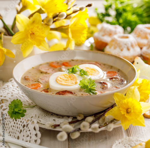 Photography The sour soup (Żurek), polish Easter soup with the addition of sausage, hard boiled egg and vegetables in a ceramic bowl, close up