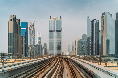 Dubai metro railroad at skyscrapers buildings skyline background.
