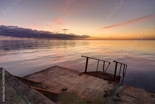 Concrete sea wharf against the backdrop of a beautiful evening landscape © madhourse