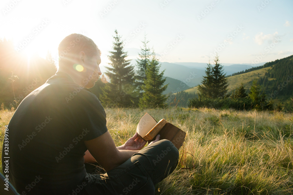 A man looks at a notebook outdoors