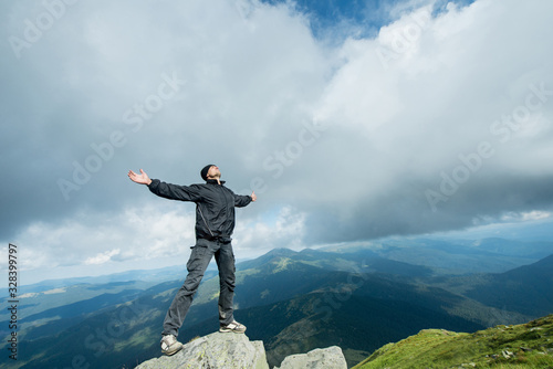 Happy young traveler on the top of the mountain