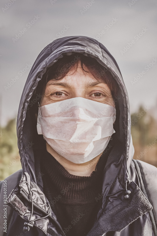 Portrait of a woman in a disposable medical mask. Coronavirus epidemic. Flu. Coronavirus epidemic. Wuhan symptoms of coronavirus and epidemic virus. Chinese woman in a mask. Portrait of a woman in a disposable medical mask. Coronavirus epidemic. Flu. Coronavirus epidemic. Wuhan symptoms of coronavirus and epidemic virus. Chinese woman in a mask.