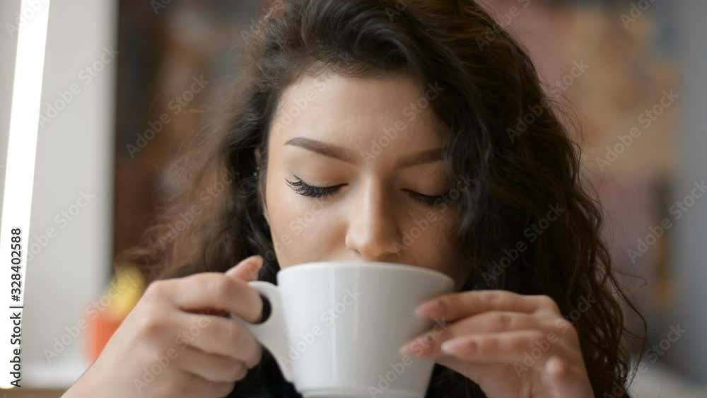 Beautiful girl drinks fresh cappuccino with froth at the bar Beautiful girl drinks fresh cappuccino with froth at the bar