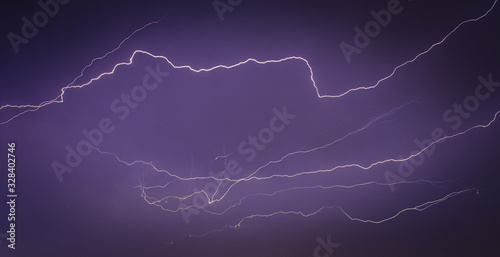 Lightning strikes in the city seen through the window, thunder in the night, massive lightning on the city, night cityscape with strong lightning, majestic view on night town in dark stormy night